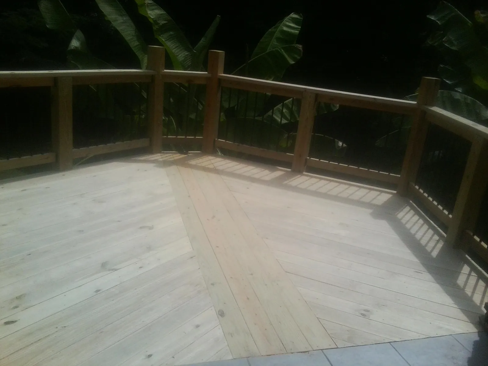 New wood deck and railing built off the back of a home in Pratt