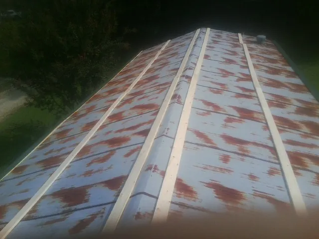 Rusted metal roof panels with new wood purlins before replacement — Storm Damage Roof Repair in Pratt by Roofing Brothers